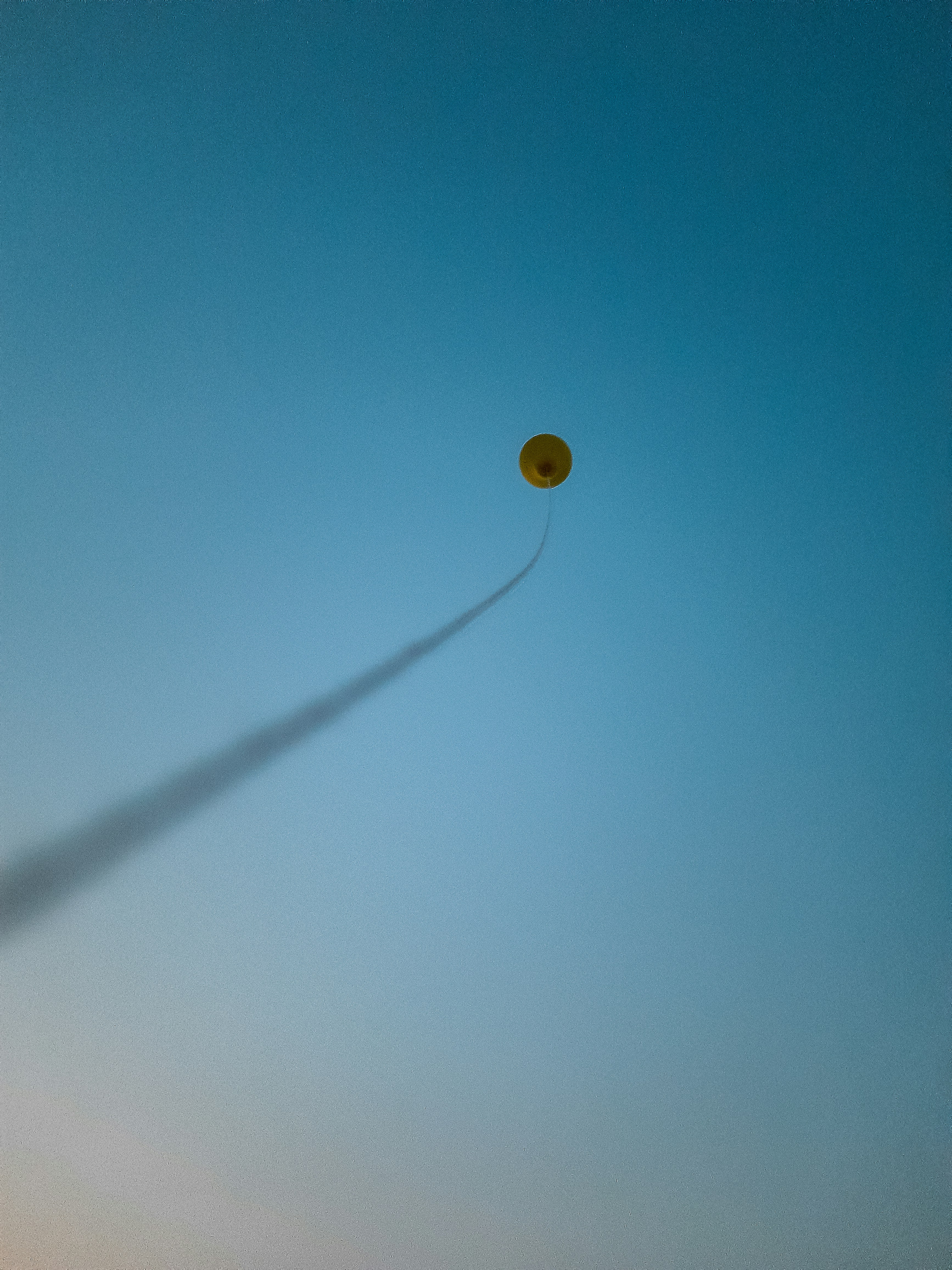 a yellow balloon in the sky