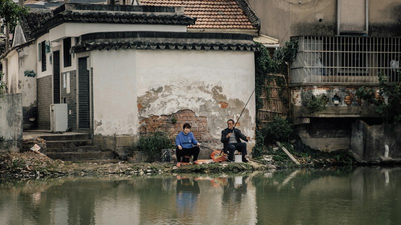 elderly couple relaxing in Suzhou classical garden with tea cup in hand