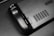 The image features a close-up view of a black gaming controller with visible buttons labeled R4 and R5. The surface appears sleek and matte, with a grid-like vent design next to the buttons. A partial brand name, 'VALVE', is visible in the corner.
