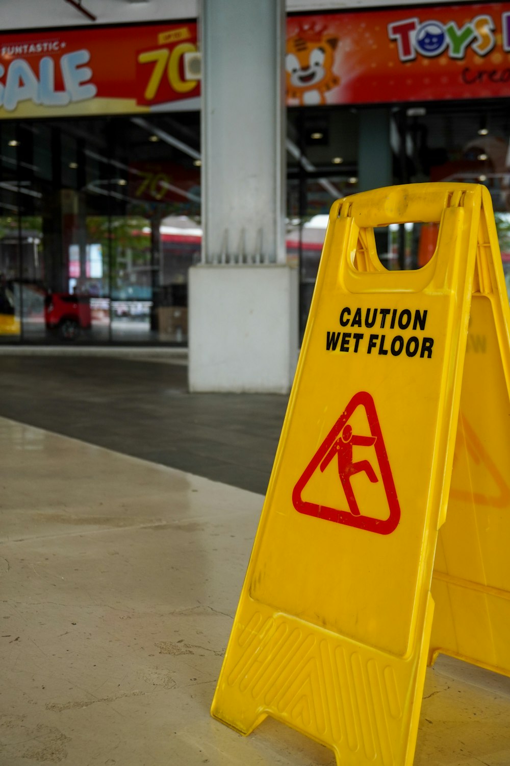 a yellow sign on a sidewalk