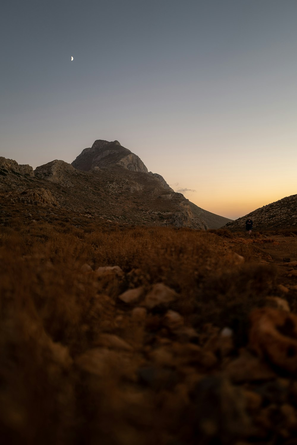 a rocky mountain with a person walking on it