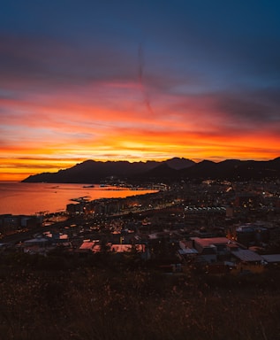 A vibrant photo of Rio de Janeiro's coastline at sunset, blending into the San Diego skyline.