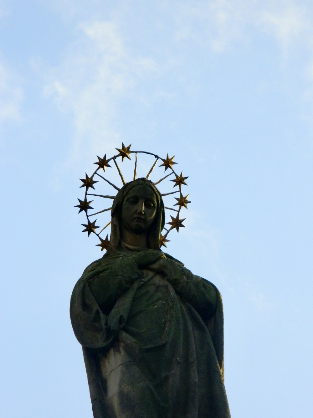 a statue of a person with a crown and cross on top