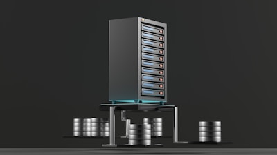 A digital rendering depicting a tall, metallic server rack positioned centrally on a platform. The server appears to have multiple blue-lit slots. Surrounding the rack, there are several stacks of cylindrical objects resembling databases or storage units, all set against a dark background.