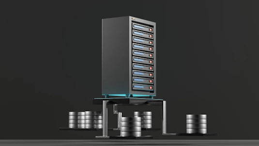 A digital rendering depicting a tall, metallic server rack positioned centrally on a platform. The server appears to have multiple blue-lit slots. Surrounding the rack, there are several stacks of cylindrical objects resembling databases or storage units, all set against a dark background.