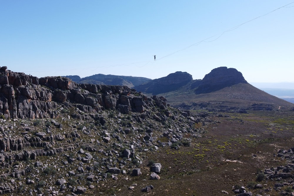 a rocky area with a bird flying in the sky