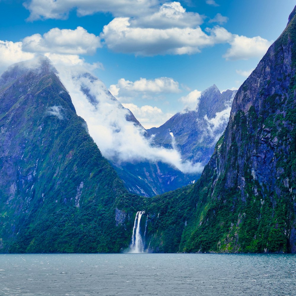 a waterfall in a lake between mountains