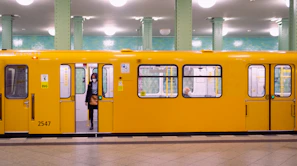 a person standing next to a yellow train