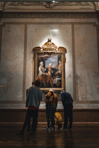 a group of people looking at a painting on a wall