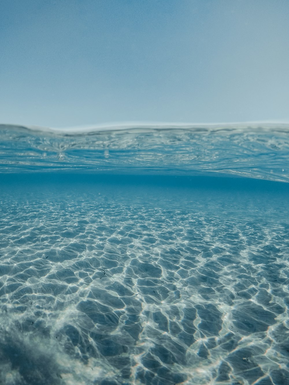 a body of water with a beach and hills in the background