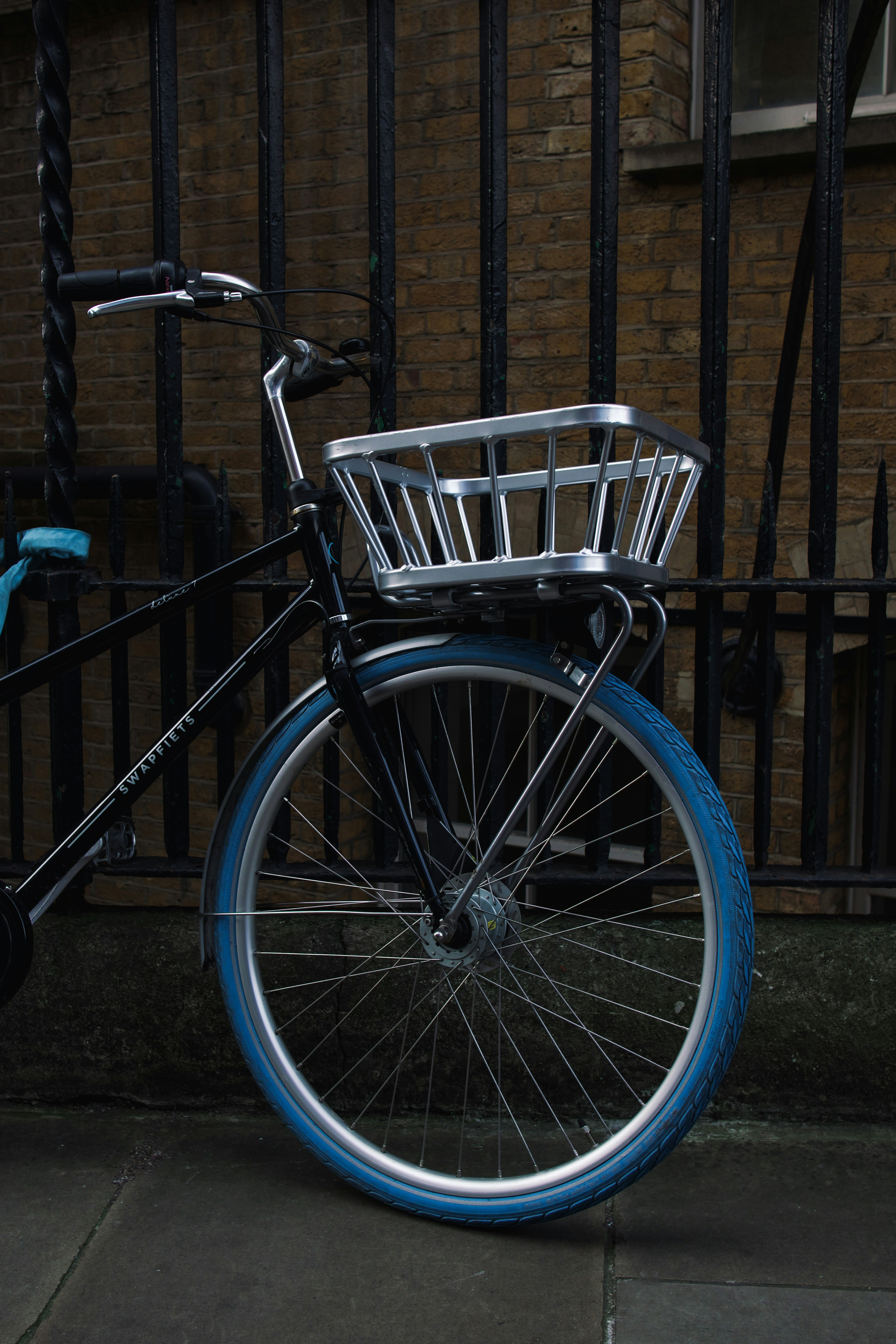a bicycle parked in front of a brick wall