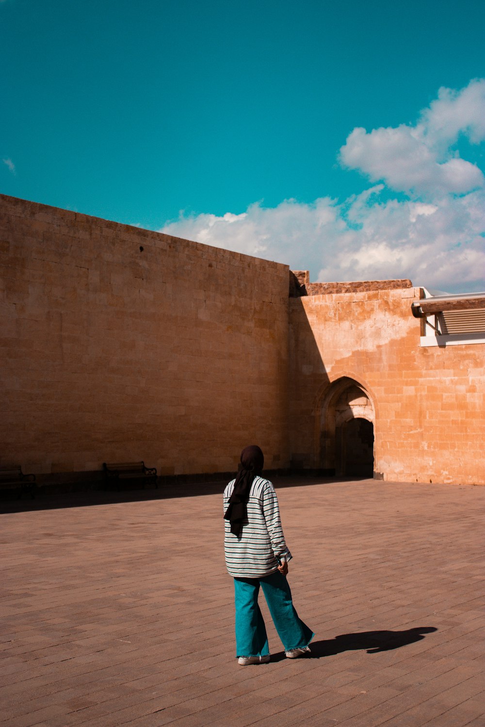 a person standing in front of a brick wall