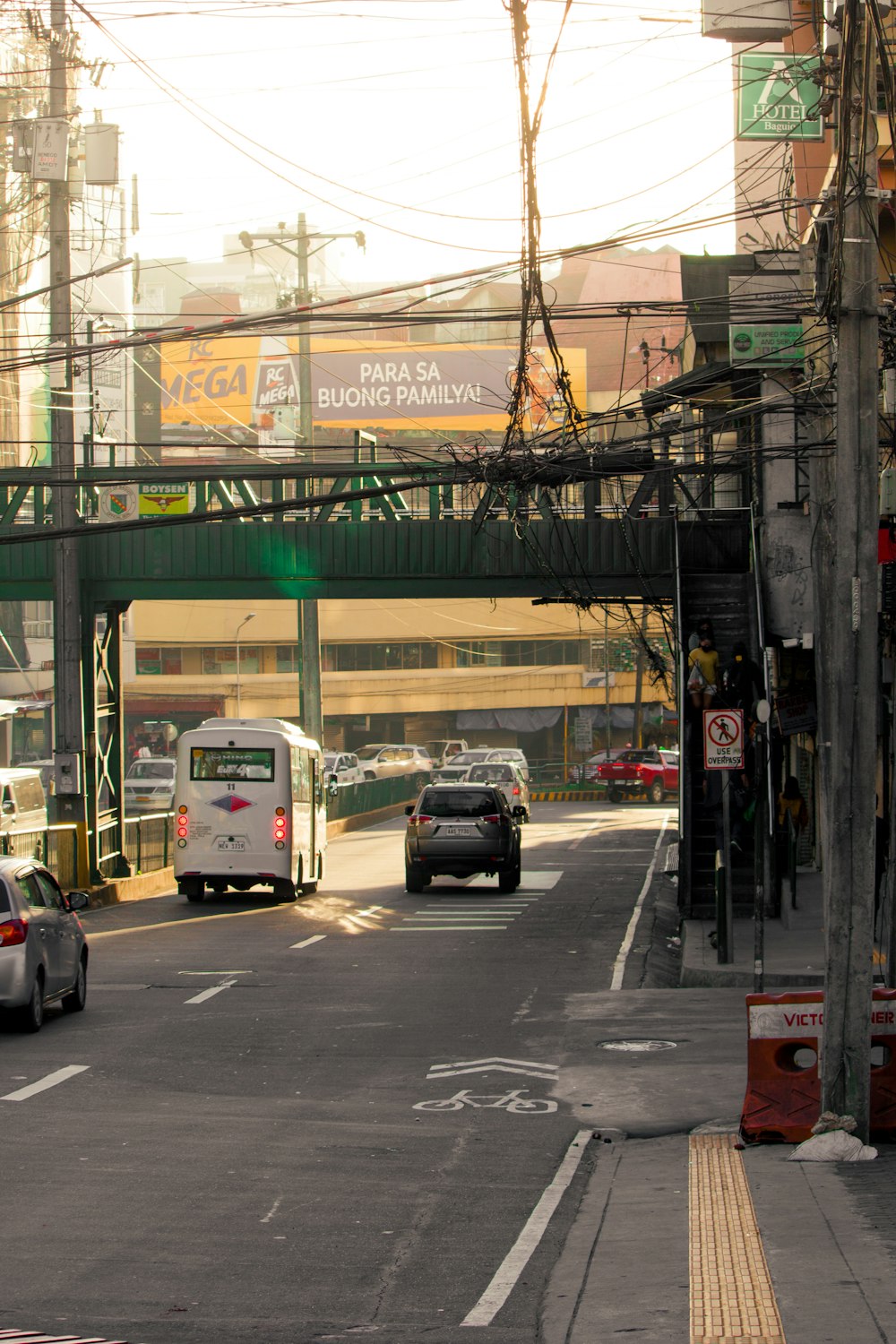 a bus and cars driving under a bridge