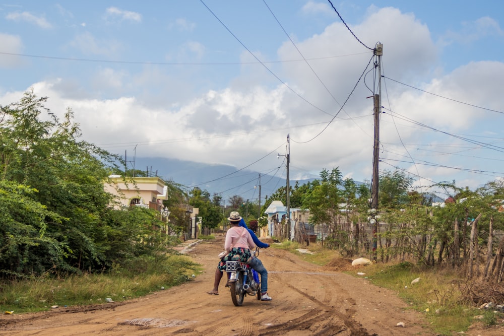 a man riding a motorcycle on a dirt road