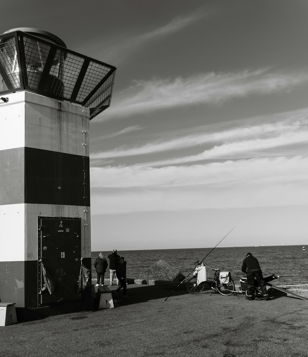 a group of people standing next to a large metal tower