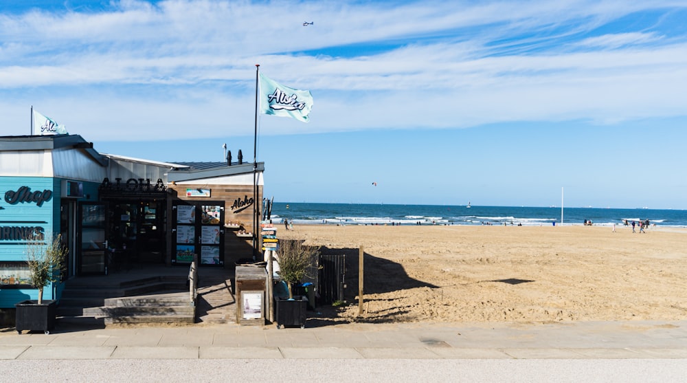 a beach with a flag and a building on the side