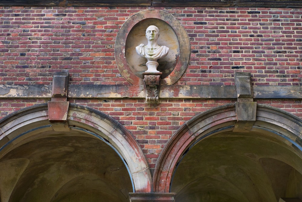 a statue on a brick wall