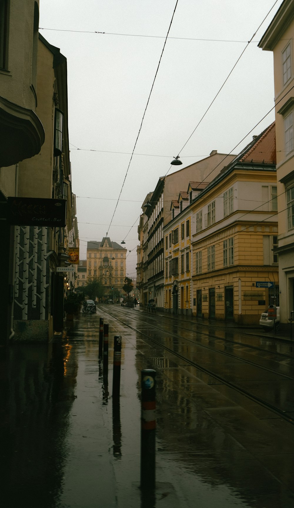a wet street with buildings on either side of it