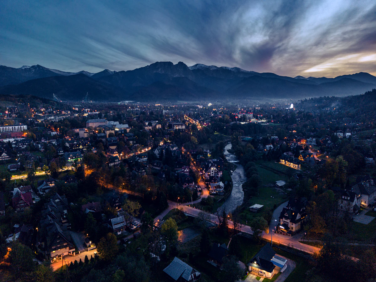 Zakopane nocą z oświetlonymi ulicami i górami w tle