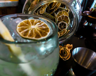 Rodajas de cítricos secos y chupitos de frutas de colores exhibidos en el mostrador de un bar.