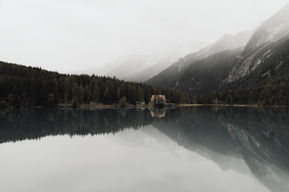 a lake with trees and mountains in the background