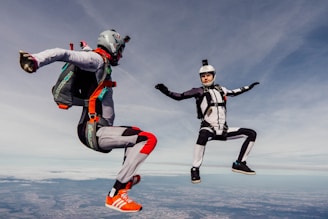 Image of skydiving suits displayed on a rack.