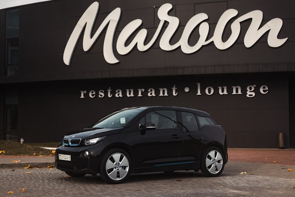 a car parked in front of a building with a sign on it