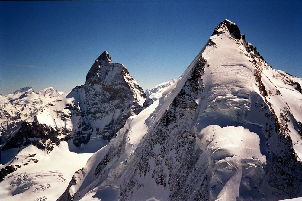 a snowy mountain with a blue sky