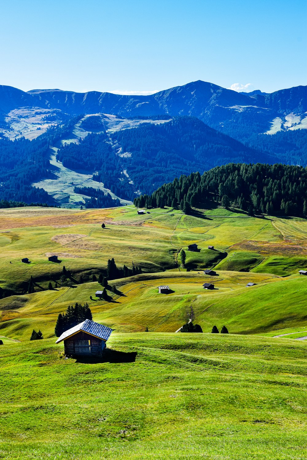 a house in a valley with mountains in the background