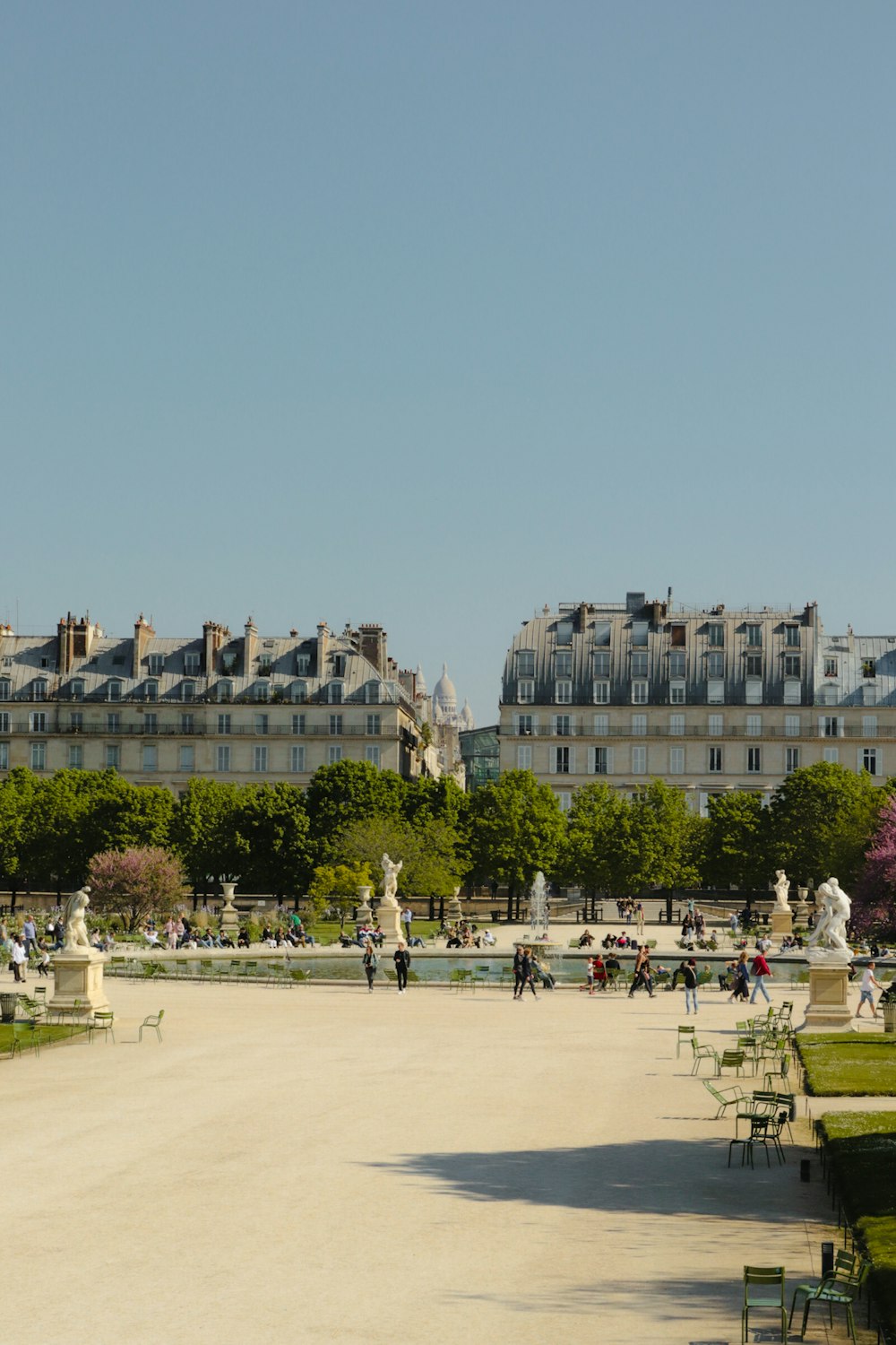 a courtyard with people and buildings in the background