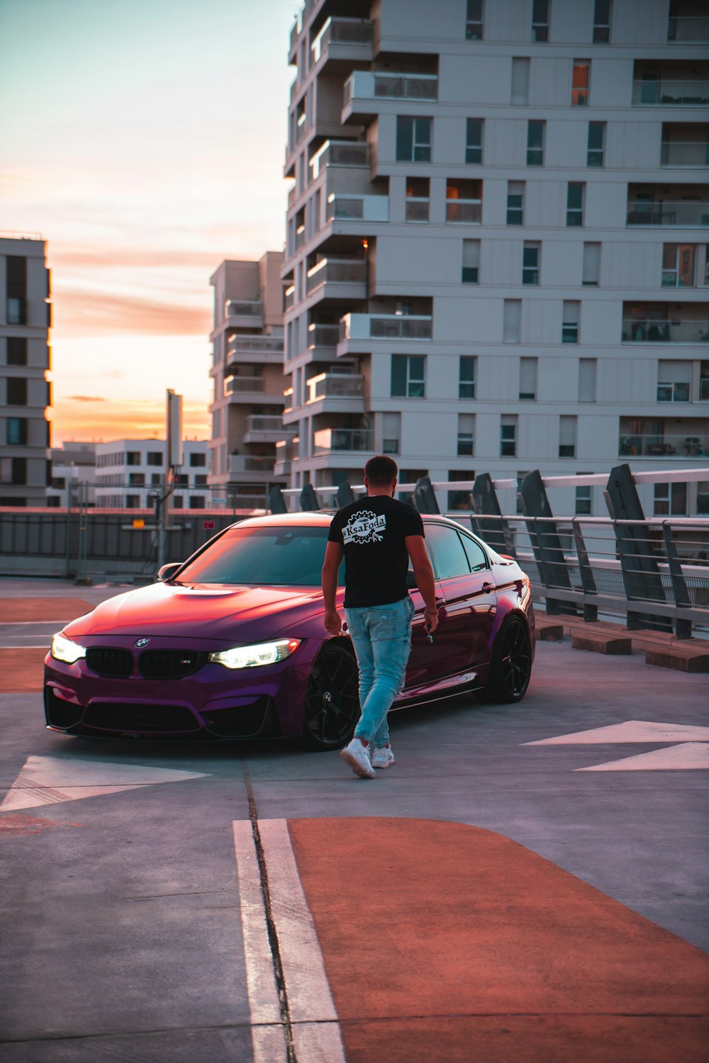 a person standing next to a red car