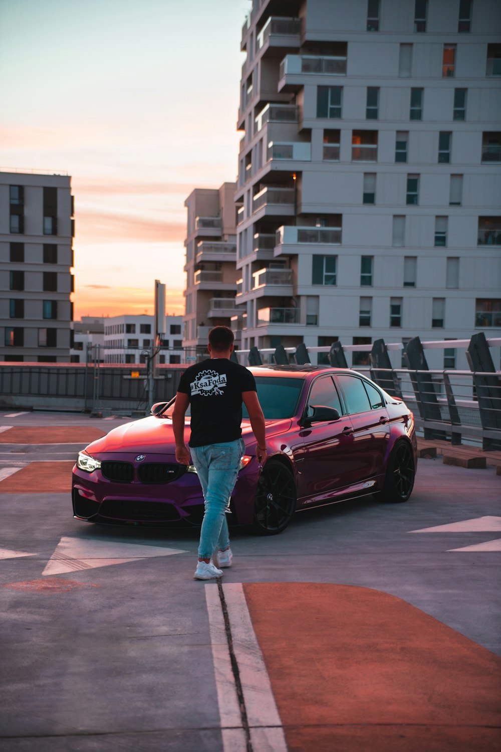 a person standing next to a red car