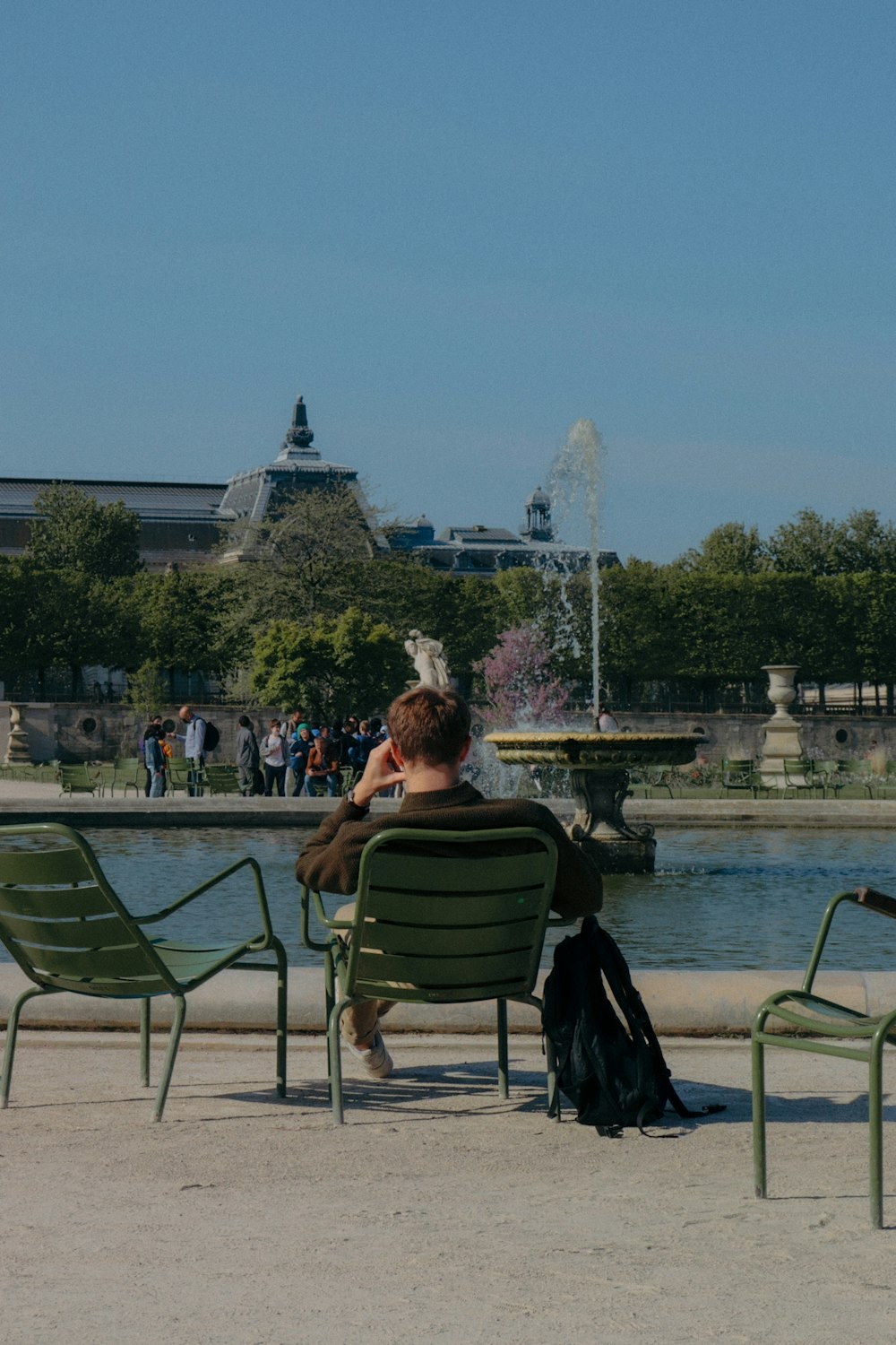 a person sitting in a chair in front of a fountain