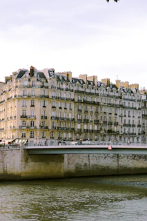 A stunning luxury apartment balcony overlooking the Danube River with Budapest's historic skyline at sunset.