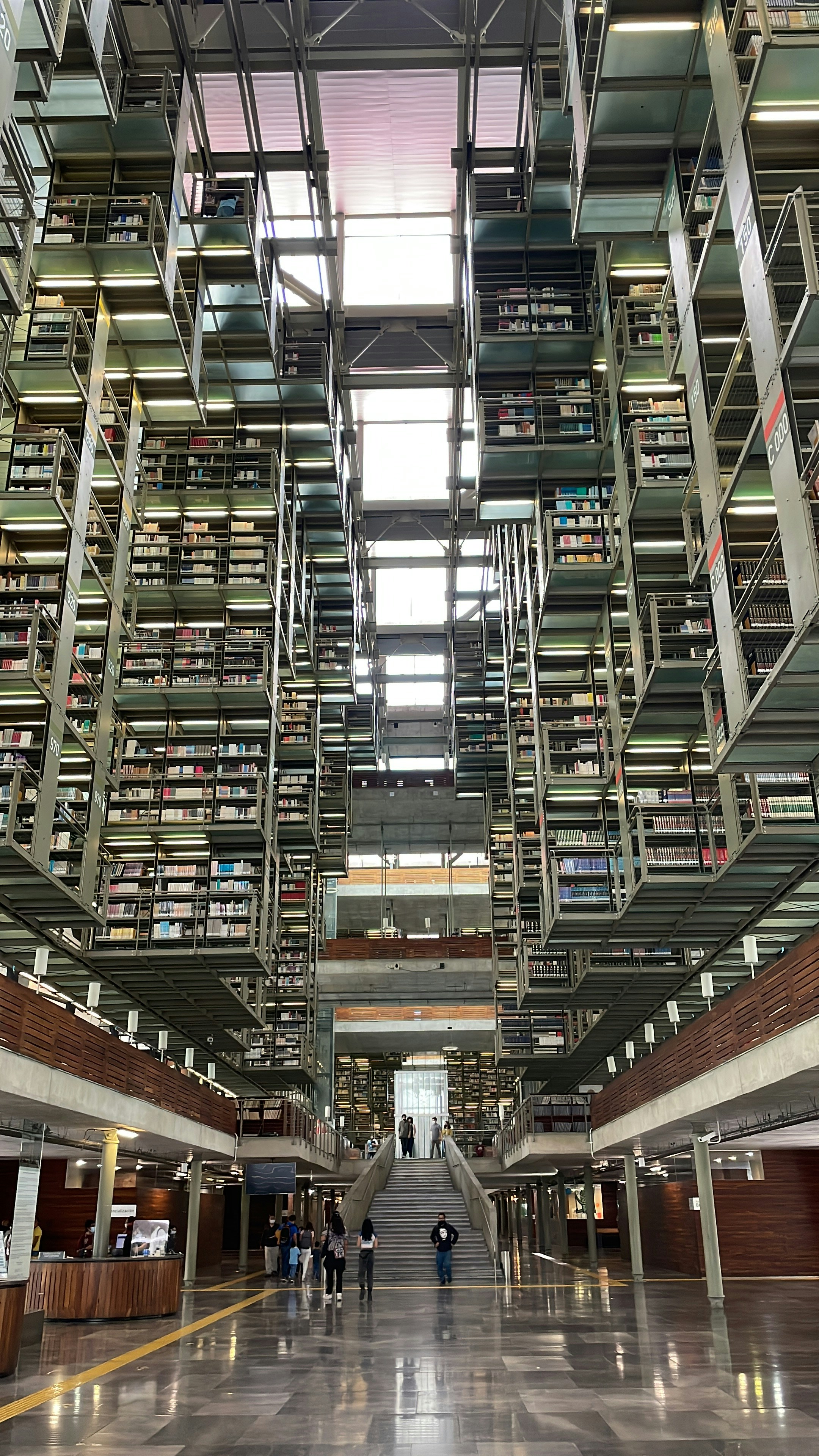 a large room with a staircase and people walking up the stairs