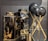 Two black and gold marble-patterned vases are displayed alongside two black spherical objects on golden stands. The vases have a glossy finish, with the marble pattern adding a luxurious touch. The spherical objects appear to be decorative, supported by elegant crisscrossed stands.