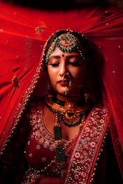 a woman wearing a colorful headdress and a red background