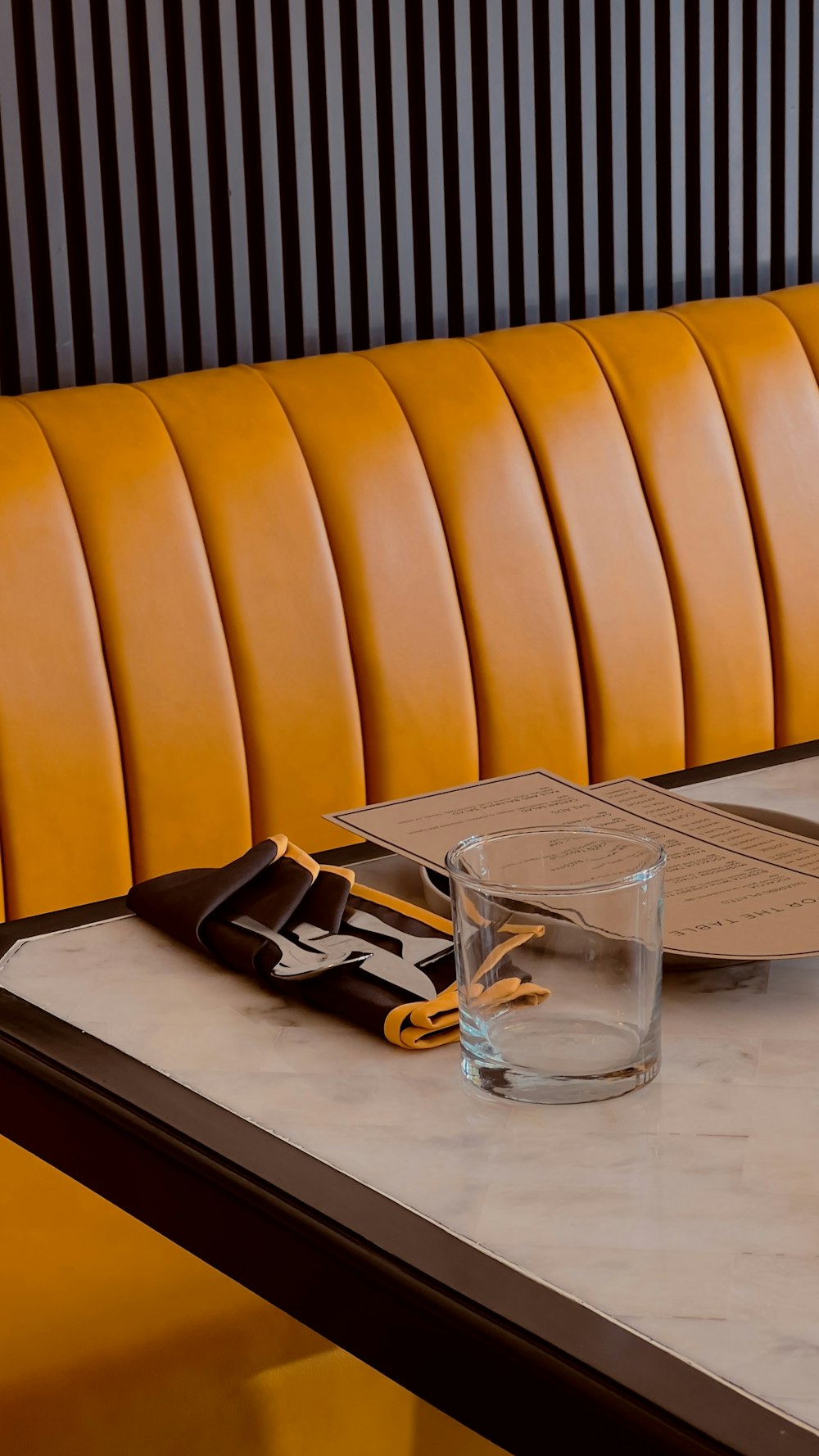 a table with a glass of water and a notepad on it