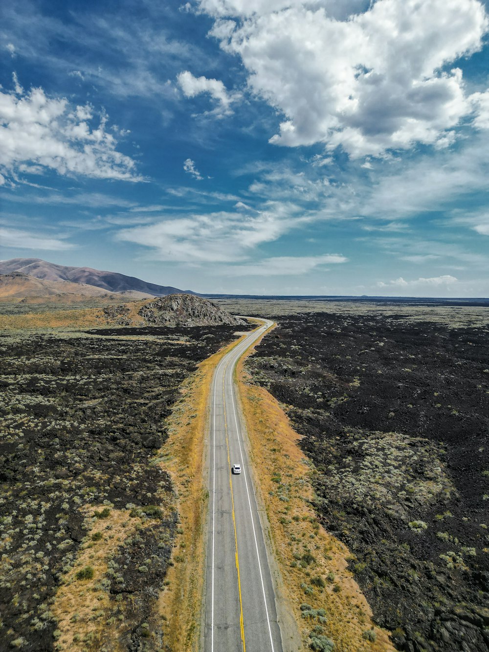 a long straight road with a car on it