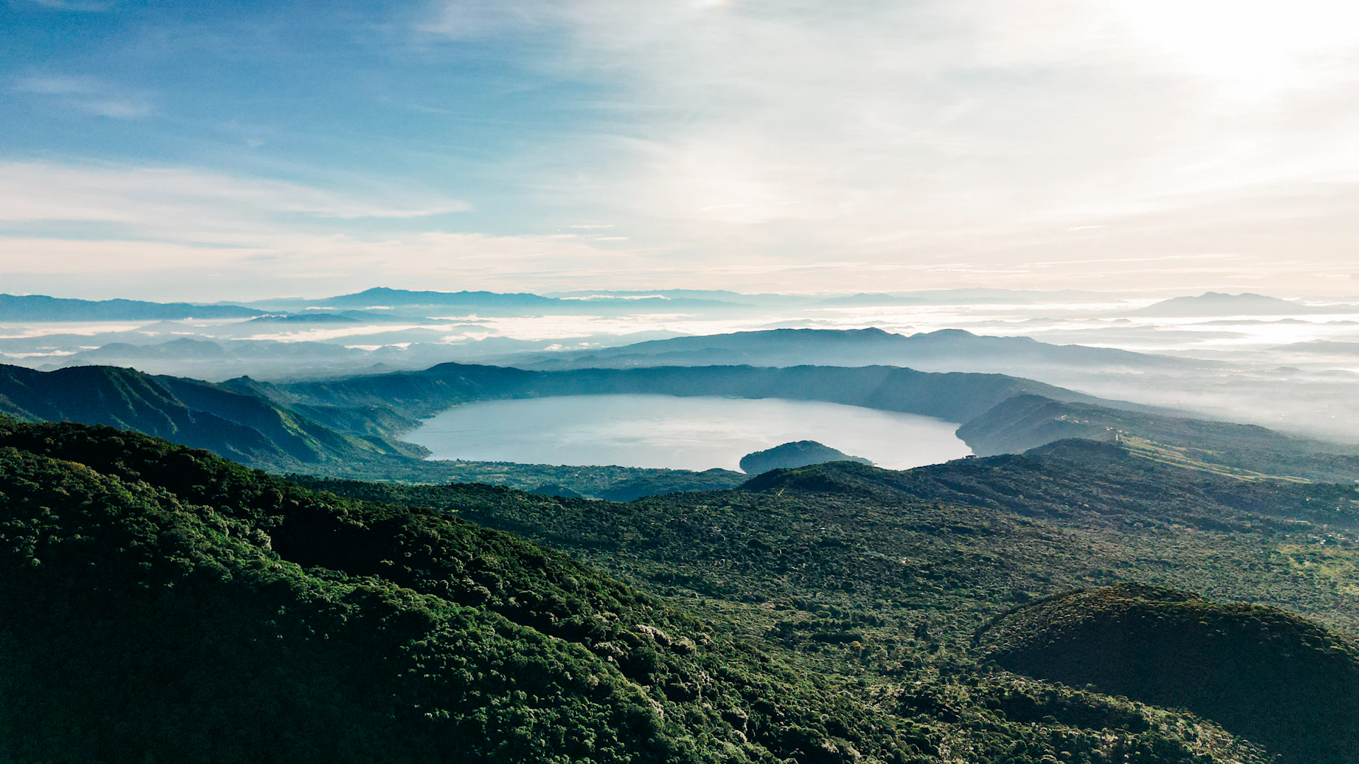 a landscape with hills and a body of water in the distance