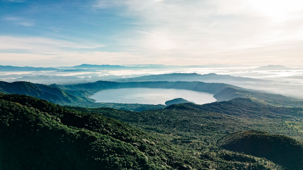 a landscape with hills and a body of water in the distance