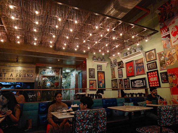 Cozy restaurant interior with impressionist art-inspired decor and warm lighting.