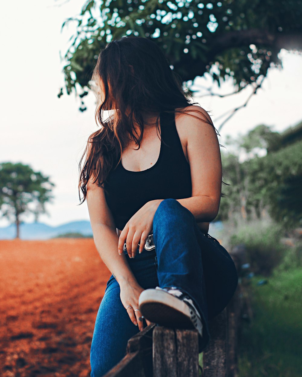 a woman sitting on a tree stump