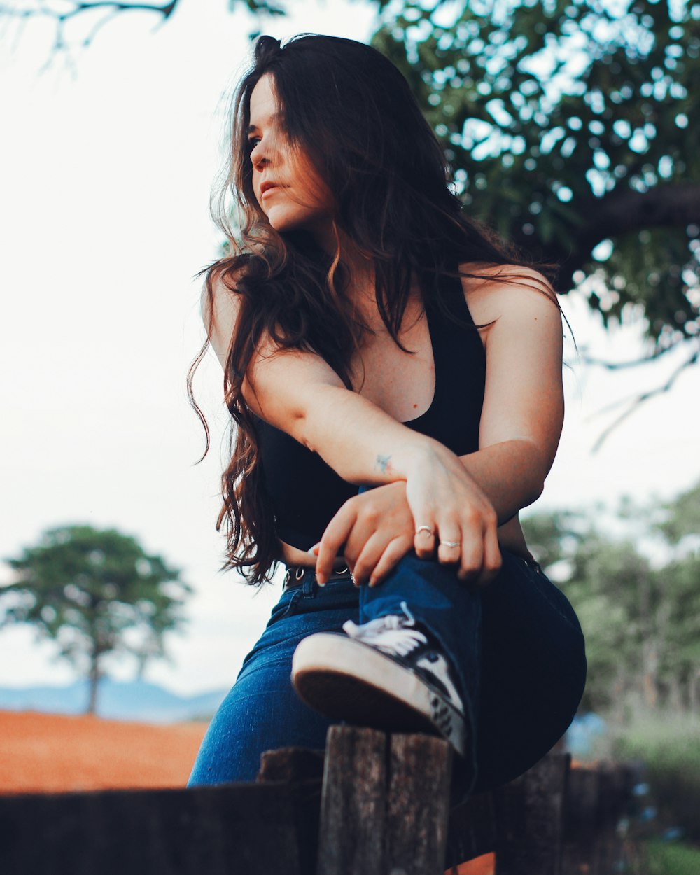 a woman sitting on a fence