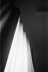 Photo of a curtain being installed with attention to detail in a cozy room