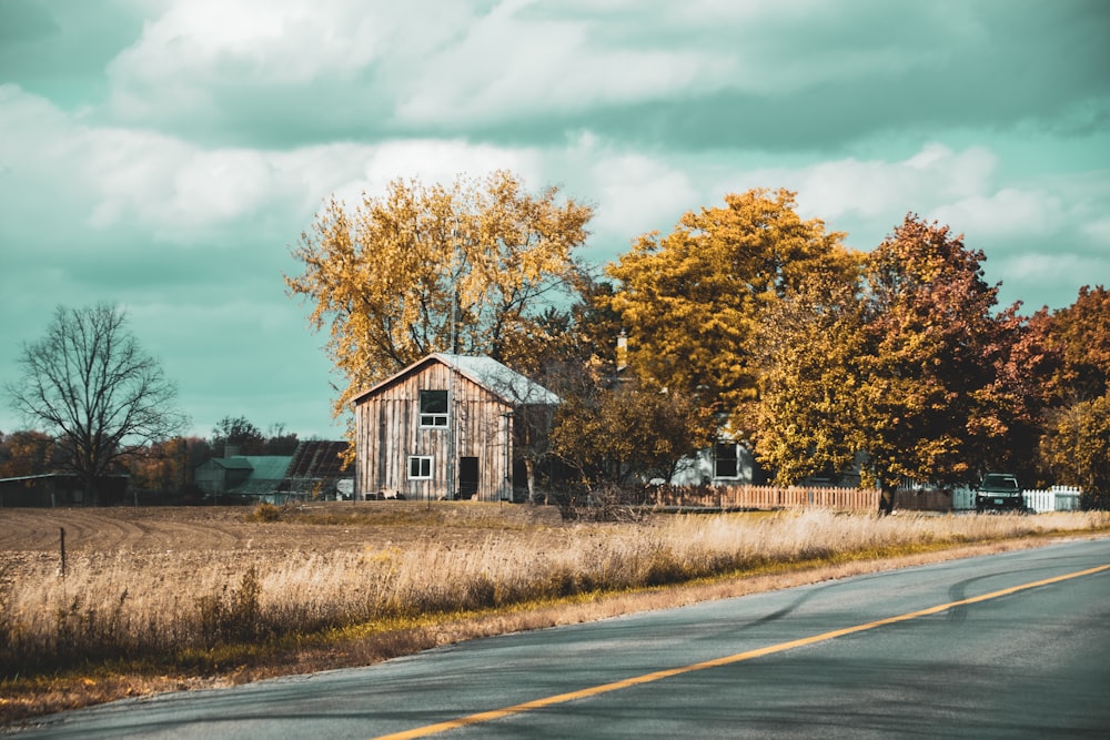 a house on the side of a road with trees around it