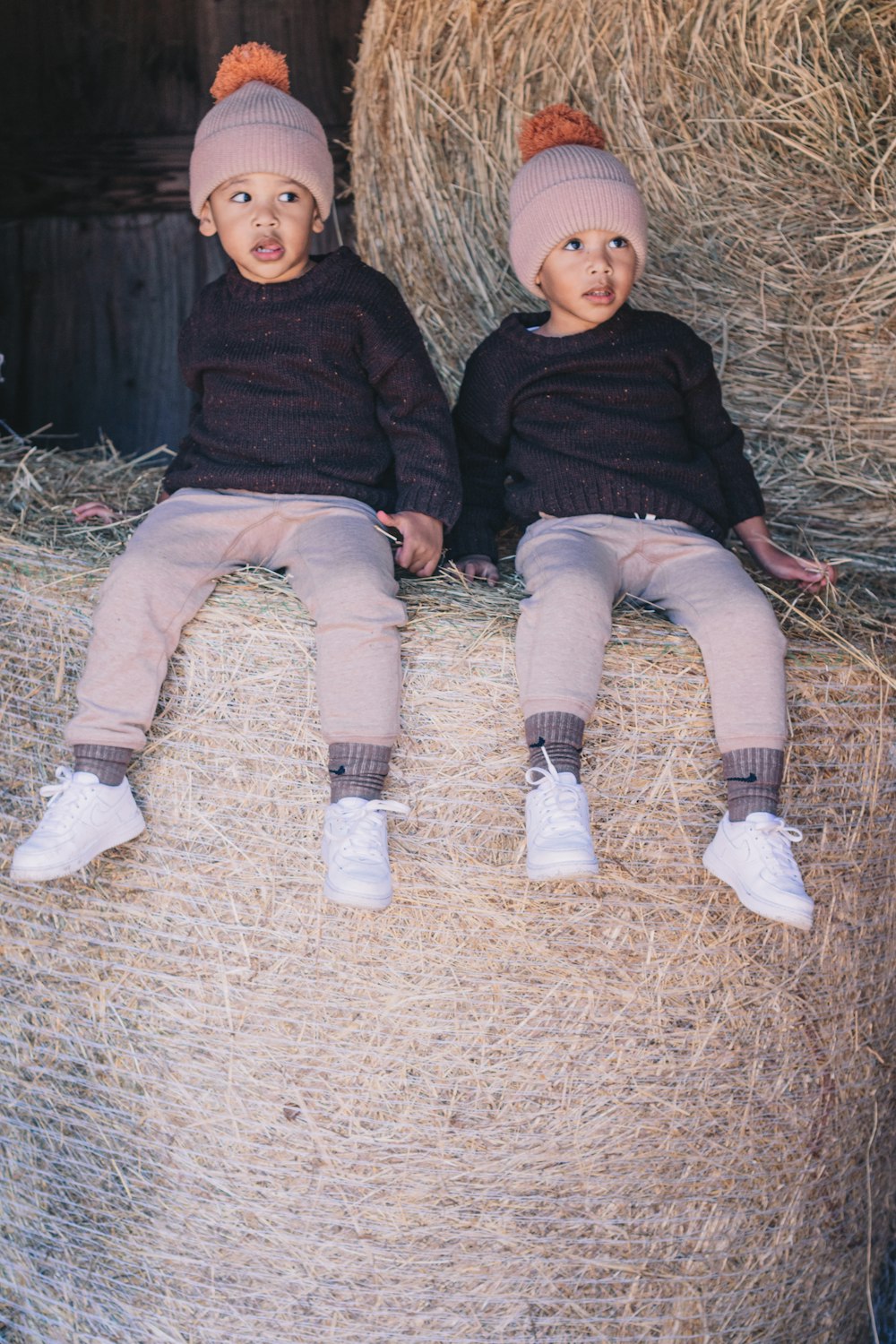 two children sitting on hay