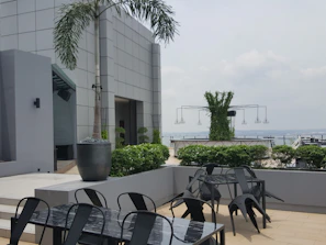 Outdoor terrace with comfortable seating and lush greenery around.