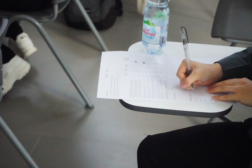 una persona escribiendo en una hoja de papel