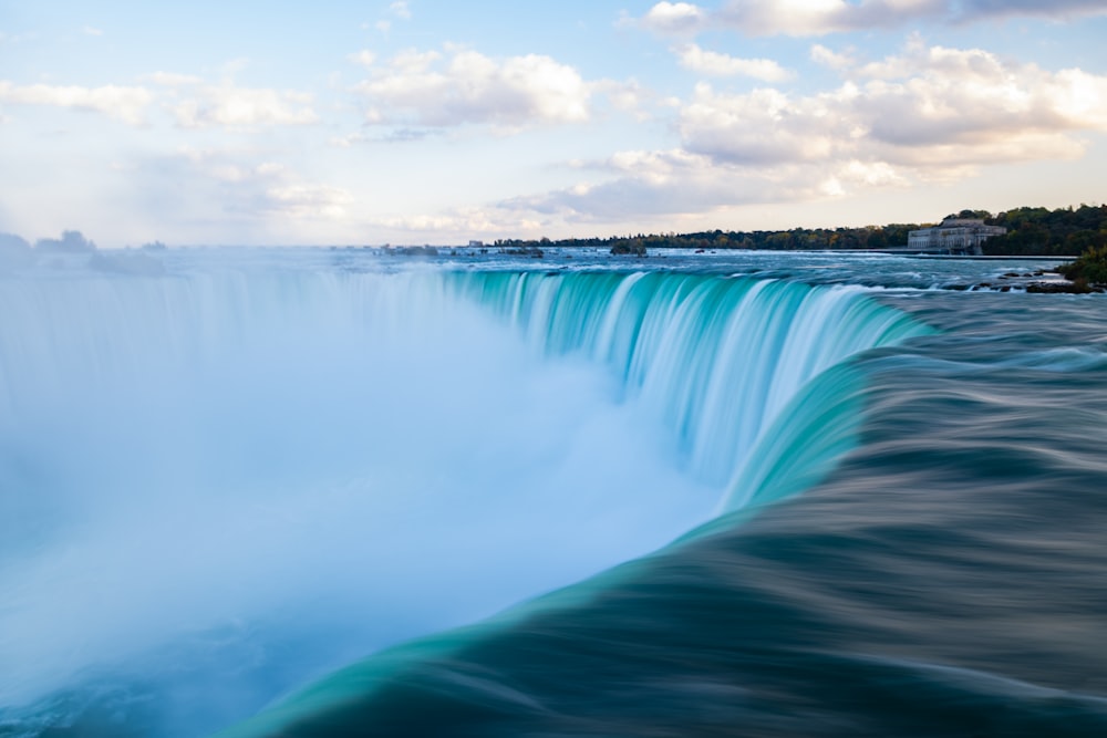 a large waterfall with a building in the background